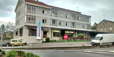 a white van parked in front of a building at HOSTAL CID in Ourense