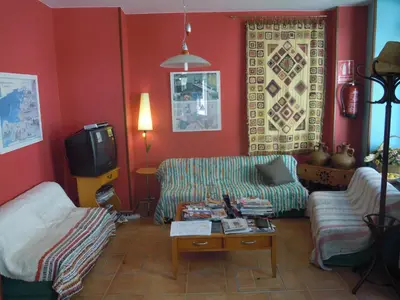 a living room with a couch and a tv at Albergue O Durmiñento in Sarria