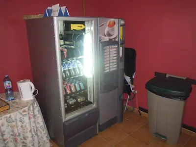 an open refrigerator with bottles of soda in it at Albergue O Durmiñento in Sarria