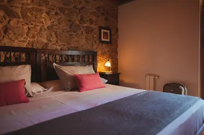 a bedroom with a bed with red and white pillows at Torres de Moreda in A Estrada