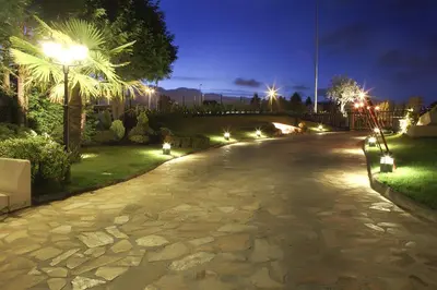 a walkway with lights in a park at night at Hotel Torre de Núñez in Lugo