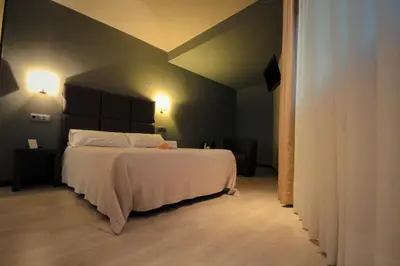 a bedroom with a large white bed in a room at Hotel Torre de Núñez in Lugo