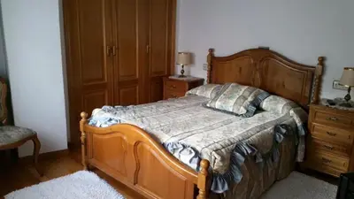 a bedroom with a wooden bed and a dresser at Hostal La Parra in Vegadeo