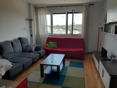 a living room with a red couch and a table at Precioso apartamento in Lugo