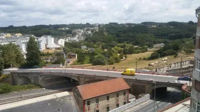 a bridge over a highway with a yellow van at Precioso apartamento in Lugo