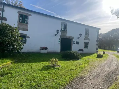 a white building with a door on the side of it at Casa Blanco in Palas de Rei