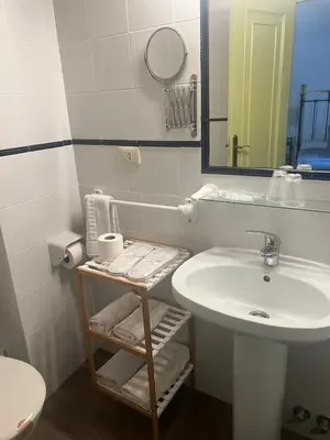a white bathroom with a sink and a mirror at Casa Blanco in Palas de Rei