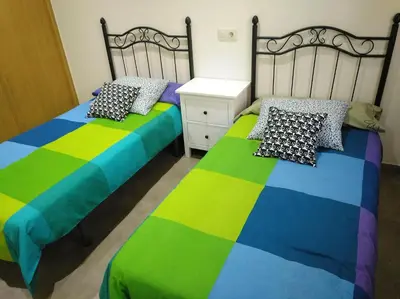 a bedroom with a colorful bed with a wooden door at Casa rural El Gato Negro in Trefacio
