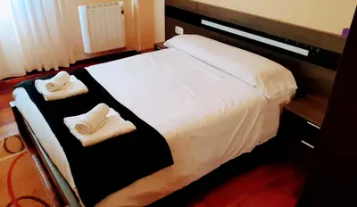 a bedroom with a bed with two towels on it at L&L Livin & Live in Arzúa