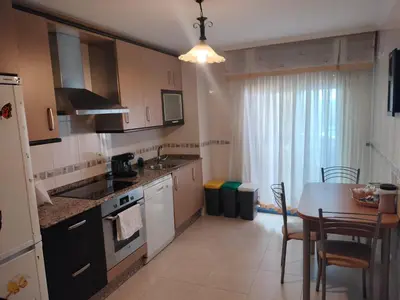 a kitchen with a table and a dining room at L&L Livin & Live in Arzúa