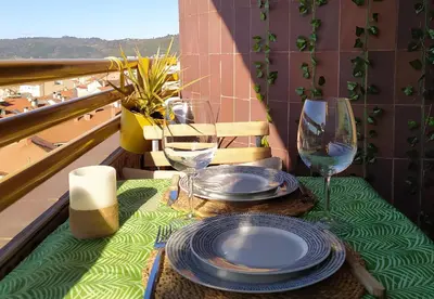a table with plates and wine glasses on a balcony at Casa FR VUT-OR-0345 in Ourense