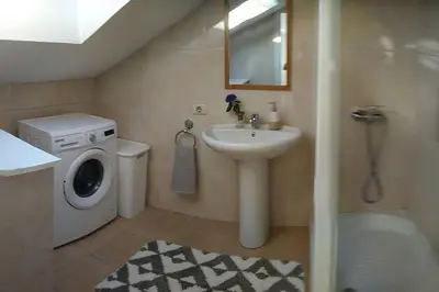 a bathroom with a sink and a washing machine at Casa FR VUT-OR-0345 in Ourense