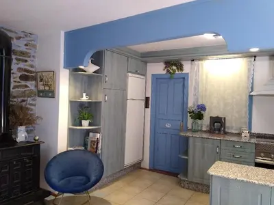 a kitchen with a blue door and a blue chair at Ribera Sacra ( apartamento Rural ) in Ferreira de Panton