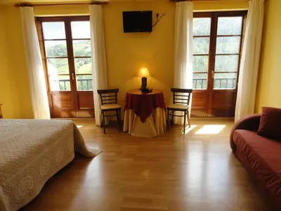 a bedroom with a table and chairs and a couch at Hotel Restaurante Casa Petronila in Taramundi