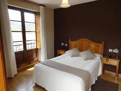 a bedroom with a bed and a large window at Hotel Restaurante Casa Petronila in Taramundi