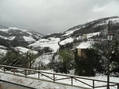 a view of a snow covered mountain with a street light at Hotel Restaurante Casa Petronila in Taramundi