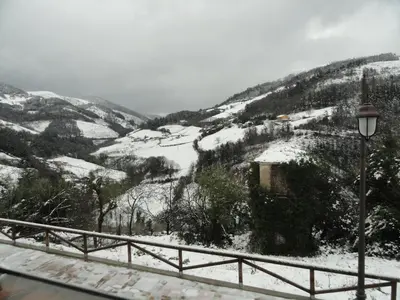 a view of a snow covered mountain with a street light at Hotel Restaurante Casa Petronila in Taramundi