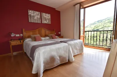 a bedroom with a bed and a large window at Hotel Restaurante Casa Petronila in Taramundi