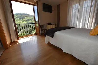 a bedroom with a bed and a large window at Hotel Restaurante Casa Petronila in Taramundi