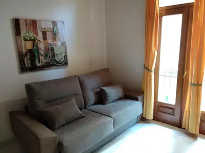 a living room with a couch in front of a window at O Tipico in Ribadavia