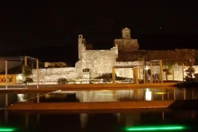 a large stone building at night with a building at O Tipico in Ribadavia