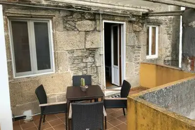 a patio with a table and chairs in front of a building at Apartamento con vistas a la catedral in Santiago de Compostela