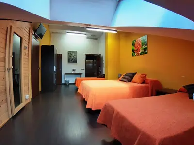 a hotel room with three beds and a blue light at Hostal Nirvana in Ponferrada