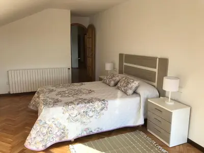 a bedroom with a large bed and a night stand at VUT-OR-182 Atico Emilia Pardo Bazán in Allariz