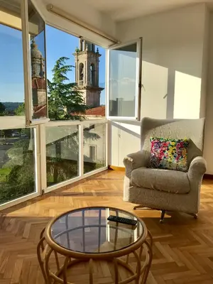 a living room with a chair and a glass table at VUT-OR-182 Atico Emilia Pardo Bazán in Allariz