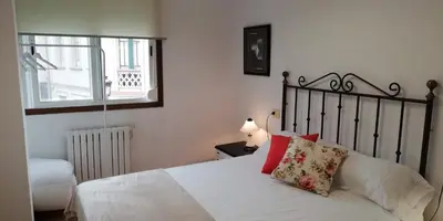 a bedroom with a bed with white sheets and red pillows at Elena in Arzúa