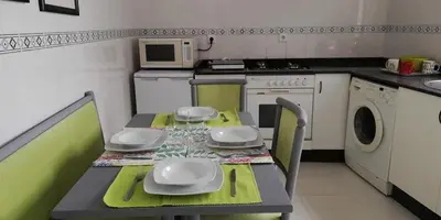 a small kitchen with a table and a microwave at Elena in Arzúa