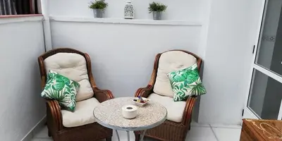 two wicker chairs and a table on a balcony at Elena in Arzúa