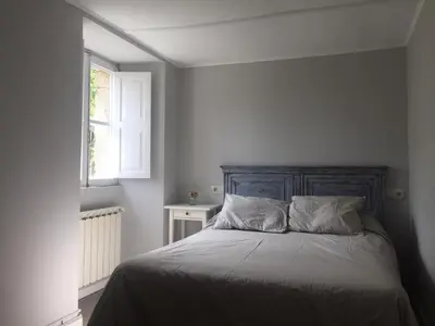 a bedroom with a bed with a wooden headboard and a window at Casa Labazá in Villarmayor