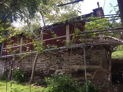 an old stone house with a red roof at Casa Labazá in Villarmayor