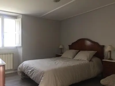 a bedroom with a bed with white sheets and a window at Casa Labazá in Villarmayor
