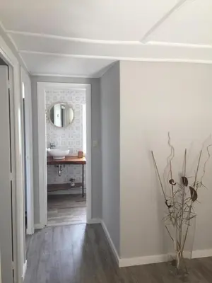 a hallway with a bathroom with a sink and a mirror at Casa Labazá in Villarmayor