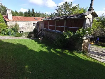 a dog standing in a yard next to a building at Casa Labazá in Villarmayor