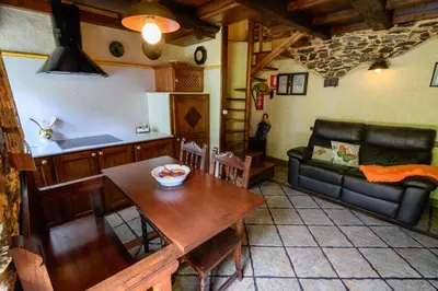 a living room with a table and a couch at Casas da Lexa in Taramundi