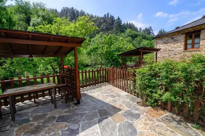 a patio with a bench and a wooden fence at Casas da Lexa in Taramundi
