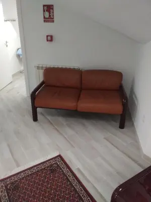 a brown couch sitting in a living room at Hotel Vilaseco in Chantada