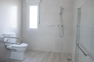 a white bathroom with a shower and a toilet at Hotel Vilaseco in Chantada