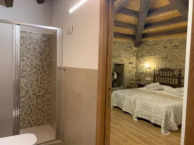 a bedroom with a bed and a walk in shower at Casa do Horreo in O Pino