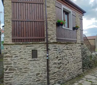 a stone building with two windows and a door at Casa do Horreo in O Pino