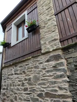 a stone building with a window with flowers on it at Casa do Horreo in O Pino