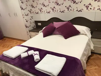 a large bed with purple and white towels on it at vivienda vacacional Iguazu in Ribadeo