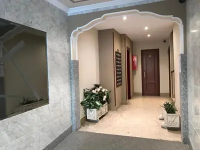 a hallway of a building with a mirror and flowers at vivienda vacacional Iguazu in Ribadeo