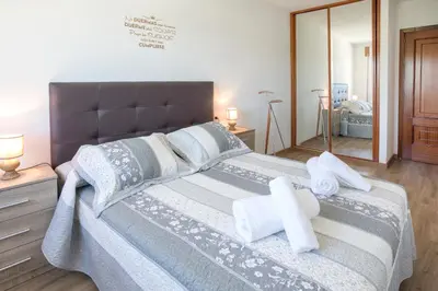 a bedroom with a large bed with towels on it at JacobeAndo in Sarria