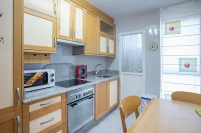 a kitchen with wooden cabinets and a stove top oven at JacobeAndo in Sarria
