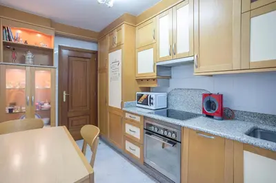 a kitchen with wooden cabinets and a red microwave at JacobeAndo in Sarria