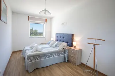a bedroom with a blue bed and a window at JacobeAndo in Sarria